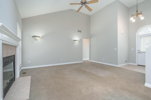 unfurnished living room with light carpet, a fireplace, high vaulted ceiling, and ceiling fan with notable chandelier