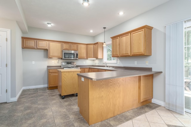 kitchen featuring sink, a center island, kitchen peninsula, stove, and decorative light fixtures