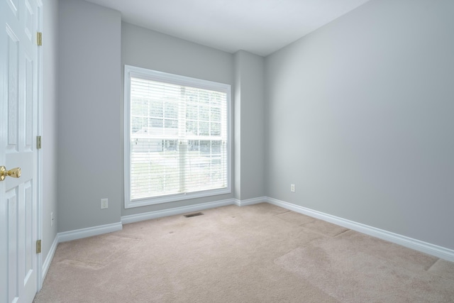 unfurnished room featuring light carpet