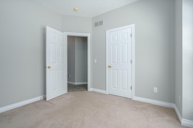 unfurnished bedroom featuring light carpet