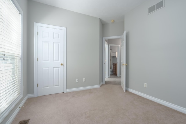 unfurnished bedroom featuring light carpet