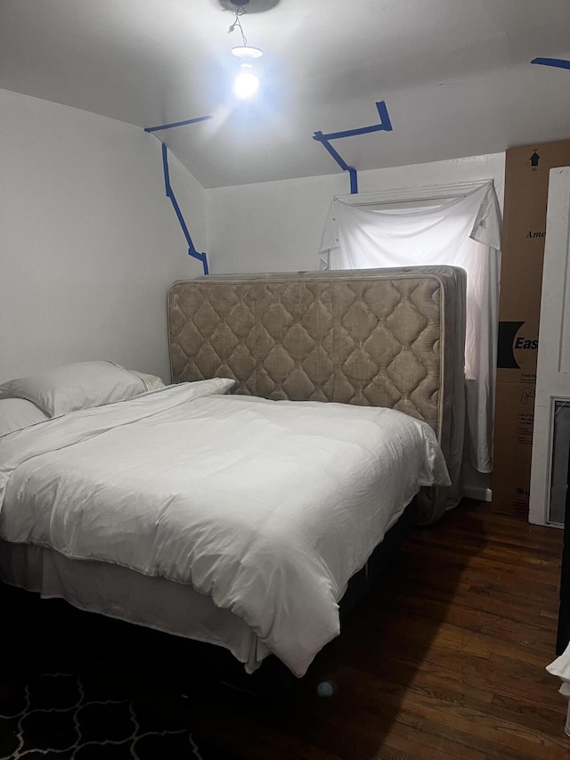 bedroom with dark hardwood / wood-style flooring