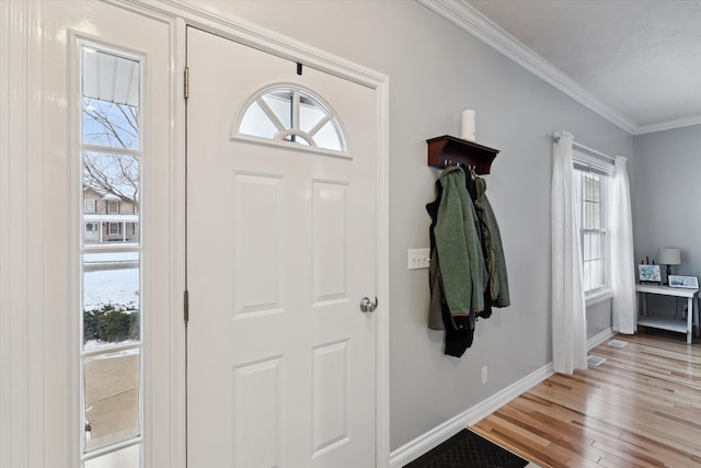 entryway with light hardwood / wood-style floors and ornamental molding