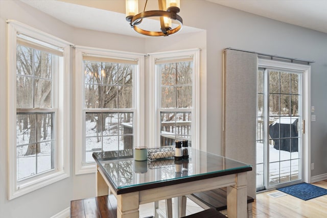 dining area with hardwood / wood-style floors and a notable chandelier