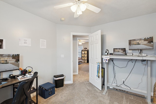 carpeted office space with ceiling fan