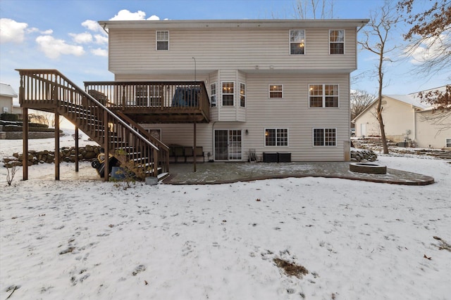 snow covered property with a wooden deck