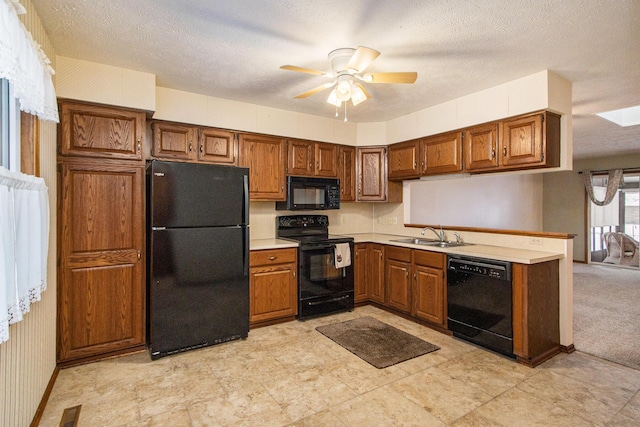 kitchen featuring a skylight, ceiling fan, sink, a textured ceiling, and black appliances