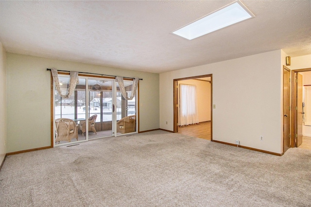 carpeted empty room with a skylight