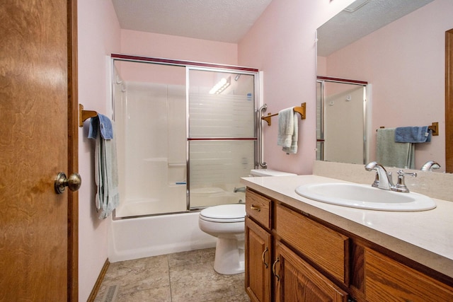 full bathroom with shower / bath combination with glass door, vanity, a textured ceiling, and toilet