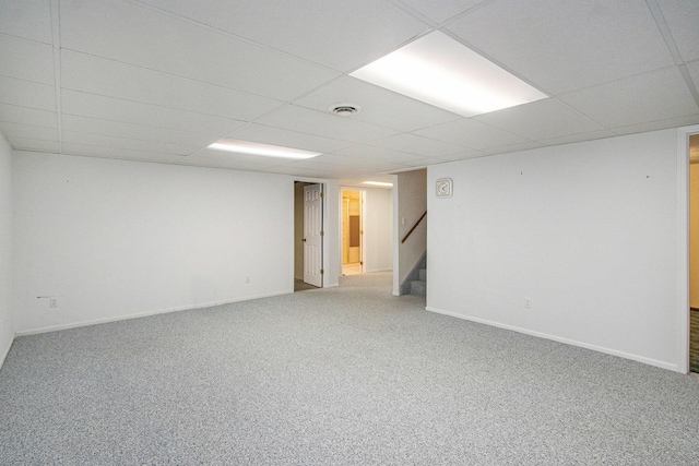 empty room featuring carpet and a drop ceiling