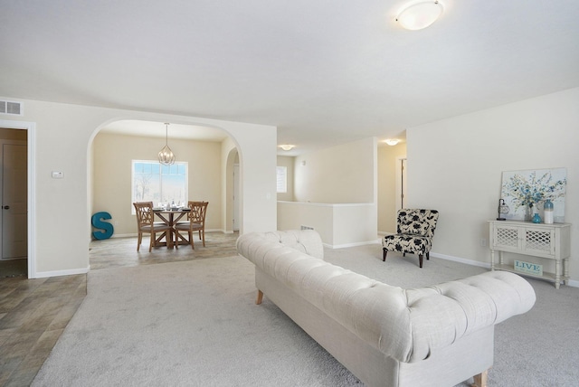 living room with carpet and a notable chandelier