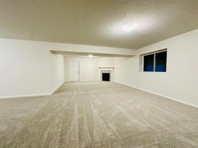 unfurnished living room with carpet floors and a textured ceiling