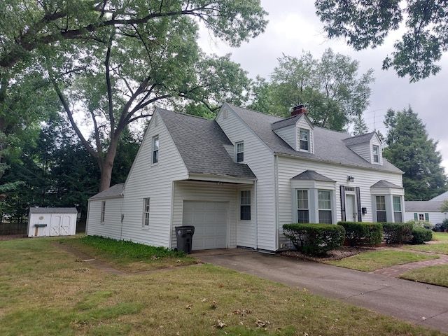 cape cod home with a storage unit, a front yard, and a garage