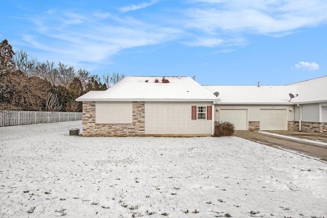 view of front of home with central air condition unit and a garage