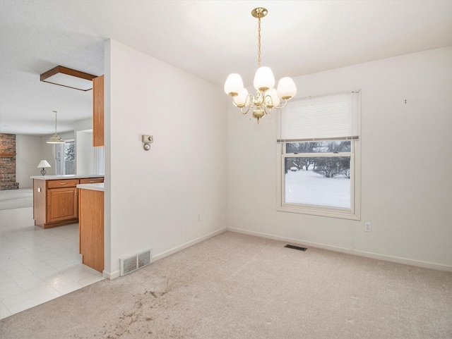 carpeted empty room featuring a chandelier