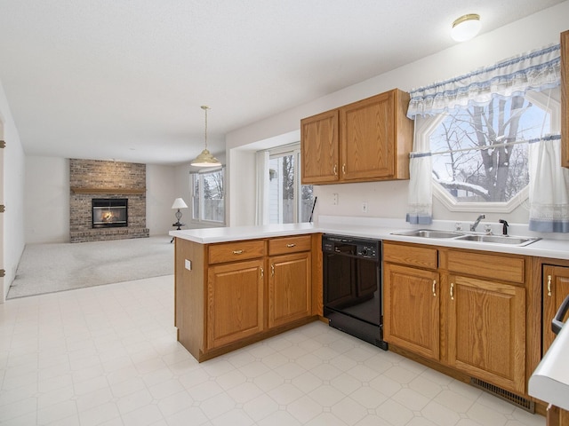 kitchen with sink, decorative light fixtures, dishwasher, kitchen peninsula, and a brick fireplace