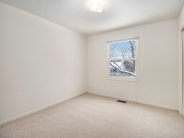 carpeted spare room featuring a textured ceiling