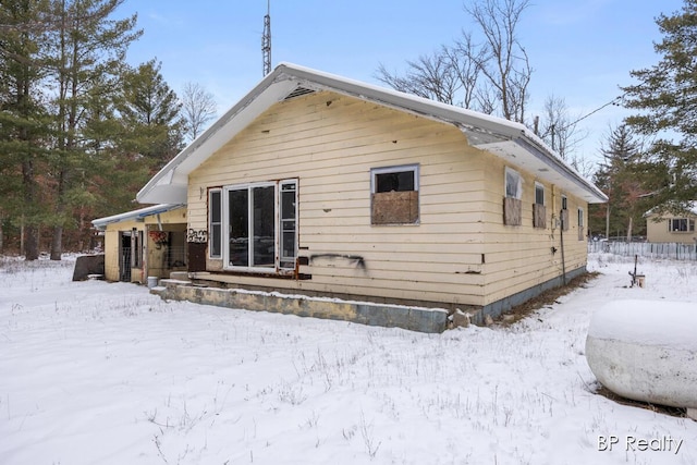 view of snow covered rear of property