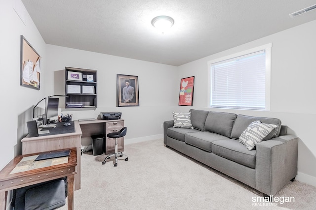 carpeted home office with a textured ceiling