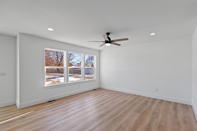 empty room with ceiling fan and light hardwood / wood-style flooring