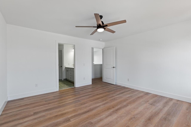 unfurnished bedroom with ensuite bathroom, ceiling fan, and light hardwood / wood-style floors