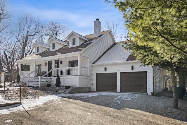 cape cod-style house featuring covered porch and a garage