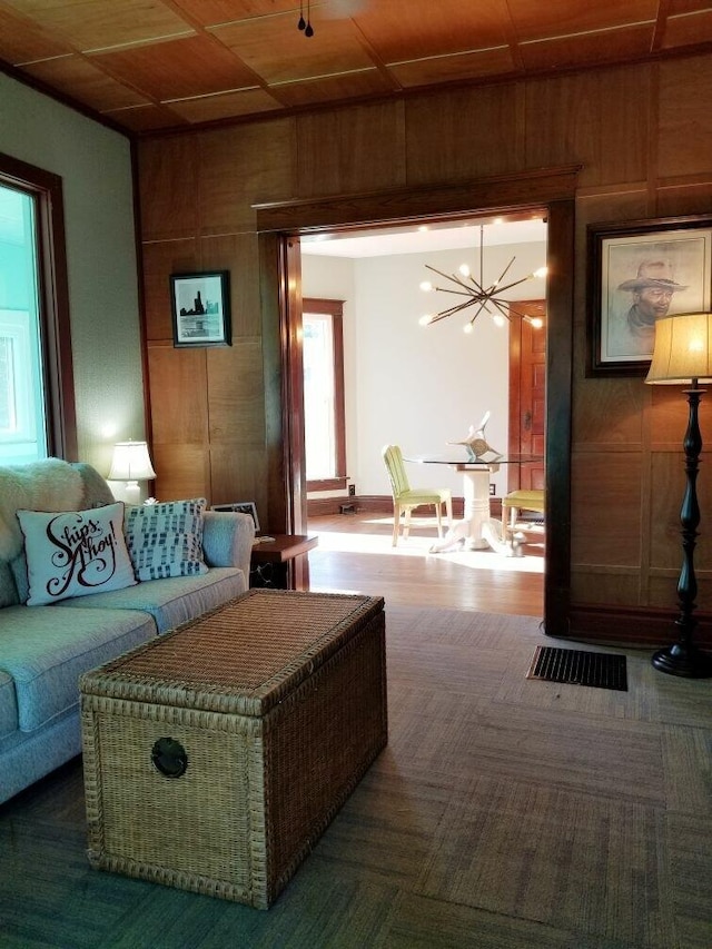 living room with a notable chandelier, wood walls, and wood ceiling