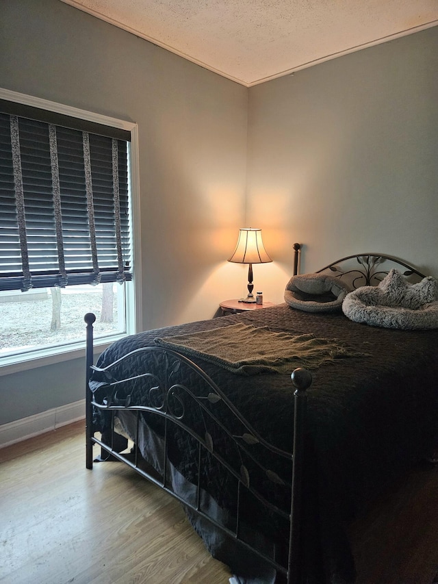 bedroom with a textured ceiling and hardwood / wood-style flooring