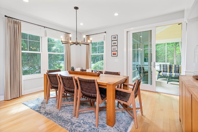 dining room with light wood-type flooring and an inviting chandelier