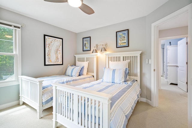 bedroom featuring ceiling fan, light carpet, and multiple windows