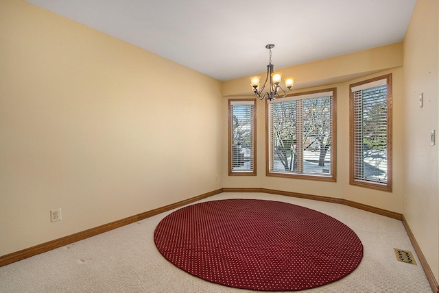 unfurnished dining area with plenty of natural light, carpet floors, and an inviting chandelier