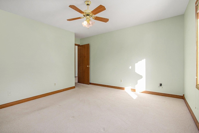 spare room featuring light colored carpet and ceiling fan