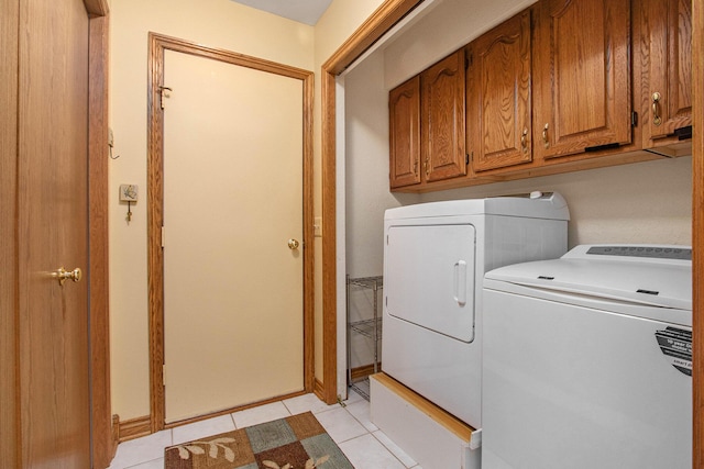 laundry room featuring light tile patterned flooring, cabinets, and separate washer and dryer