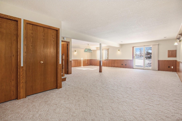 basement with wooden walls, a textured ceiling, and carpet