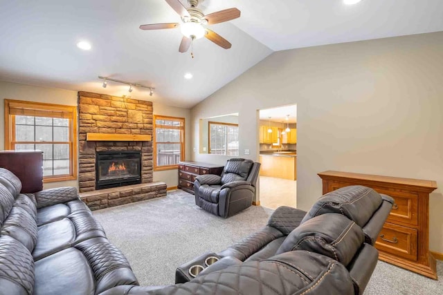 carpeted living room featuring ceiling fan, track lighting, lofted ceiling, and plenty of natural light