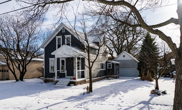 view of front of house featuring a garage and an outbuilding