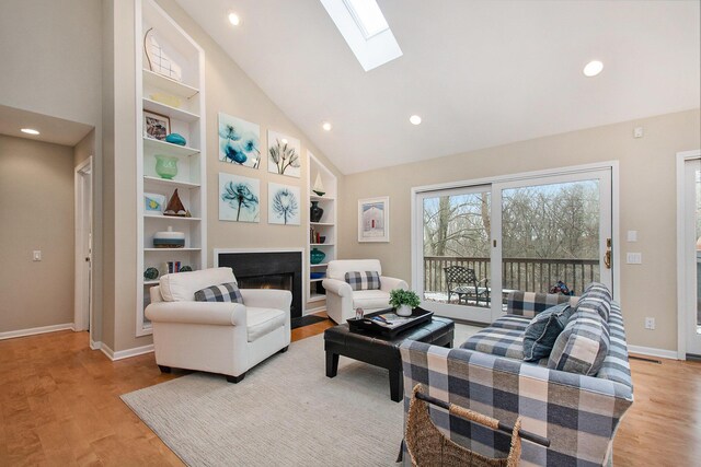 living room with light hardwood / wood-style floors and high vaulted ceiling