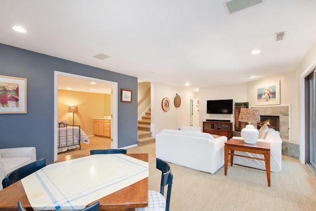 living room featuring a high end fireplace and light carpet