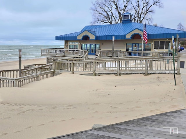 deck featuring a view of the beach, a water view, and central AC unit