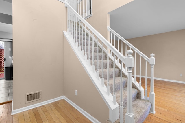 stairs featuring hardwood / wood-style flooring