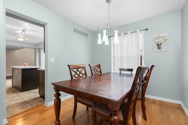 dining room featuring light hardwood / wood-style flooring and an inviting chandelier