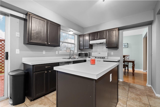 kitchen featuring sink, light tile patterned floors, appliances with stainless steel finishes, a kitchen island, and dark brown cabinetry