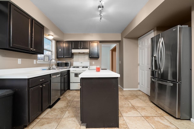 kitchen featuring rail lighting, sink, light tile patterned floors, appliances with stainless steel finishes, and a kitchen island