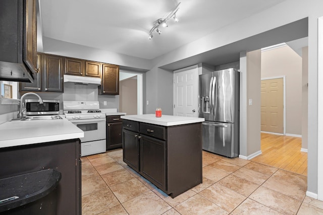 kitchen featuring gas range gas stove, a center island, sink, stainless steel fridge with ice dispenser, and light tile patterned floors