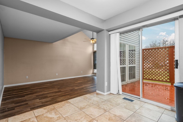 tiled spare room with ceiling fan and vaulted ceiling