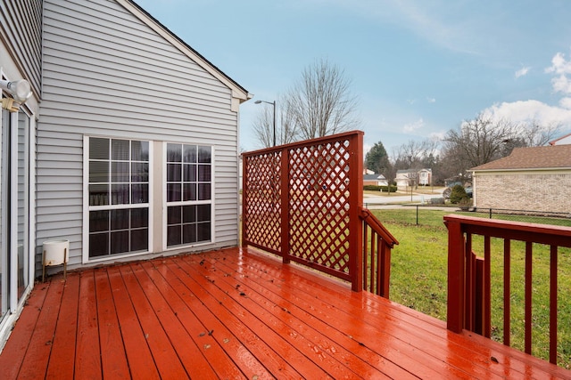 wooden deck featuring a lawn