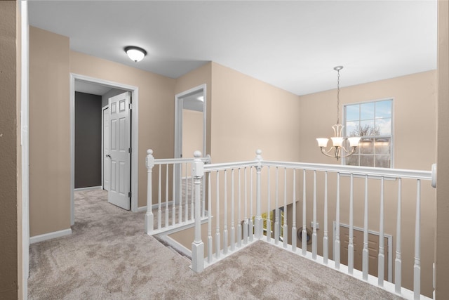 hallway featuring carpet flooring and a notable chandelier