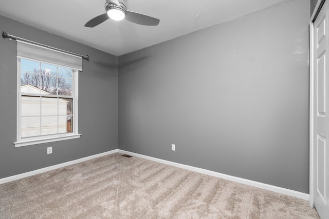 carpeted spare room featuring ceiling fan