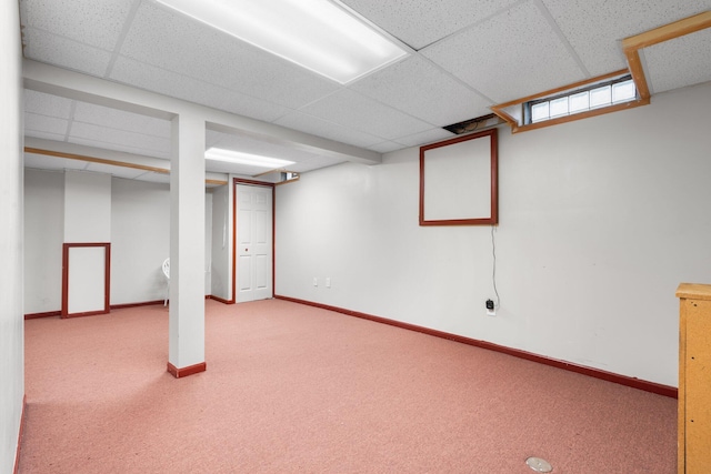 basement with a paneled ceiling and carpet floors