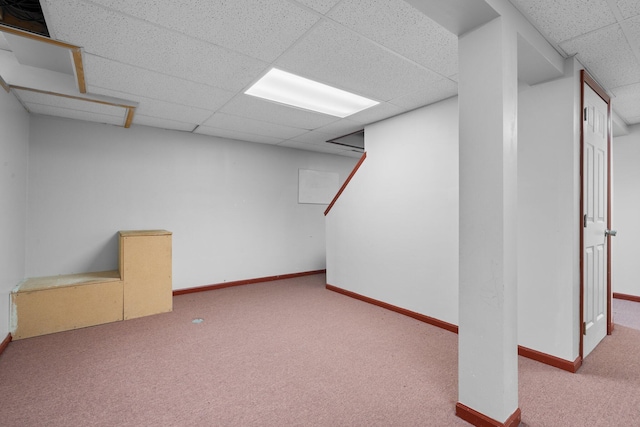 basement with a paneled ceiling and light carpet